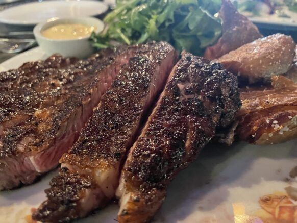 Cut steak on a plate with sides