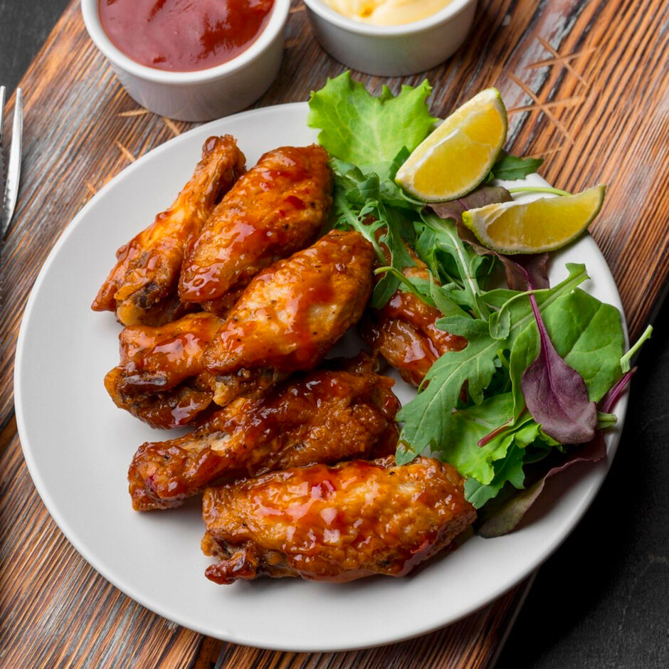 Chicken Wings on a plate with a side of salad and lime wedges