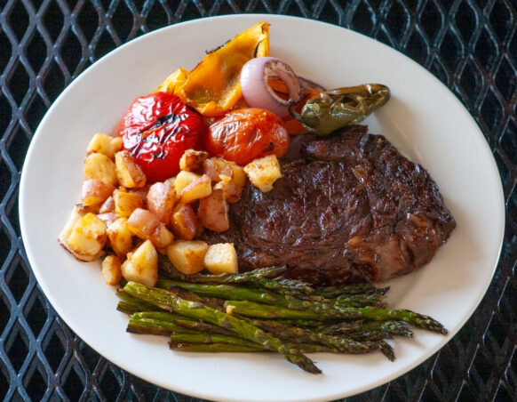 Steak, potatoes, grilled vegetables and asparagus on a plate