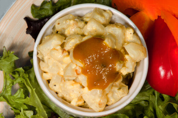Potato Salad in a small bowl with mustard on top