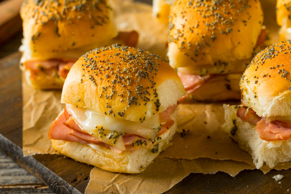 Ham and Swiss Sliders with mustard and topped with poppy seeds