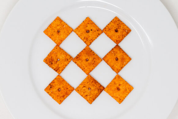 Cajun cheese crackers on white plate.